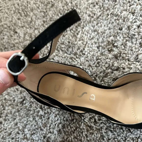 Black pumps with ankle strap and pointed toe