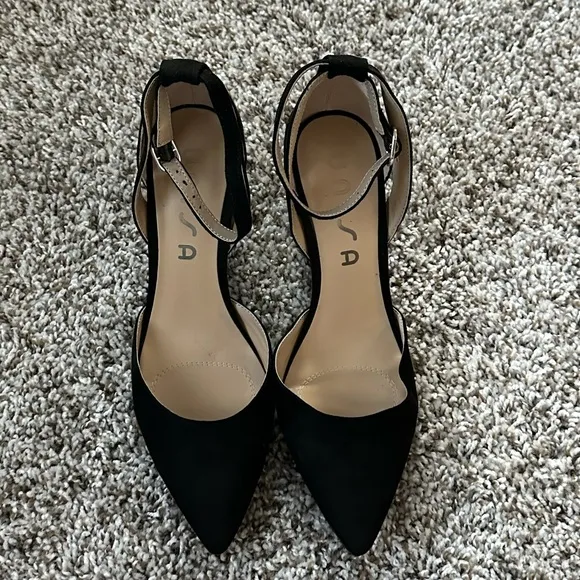 Black pumps with ankle strap and pointed toe