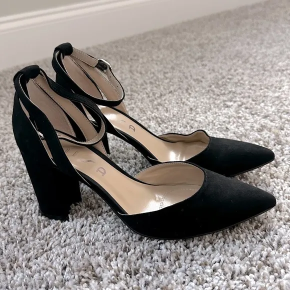 Black pumps with ankle strap and pointed toe