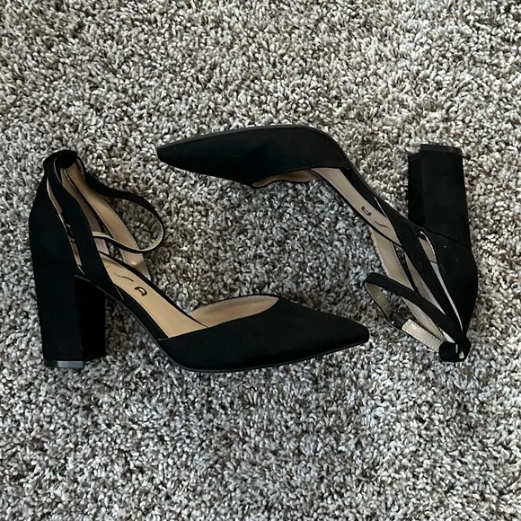 Black pumps with ankle strap and pointed toe