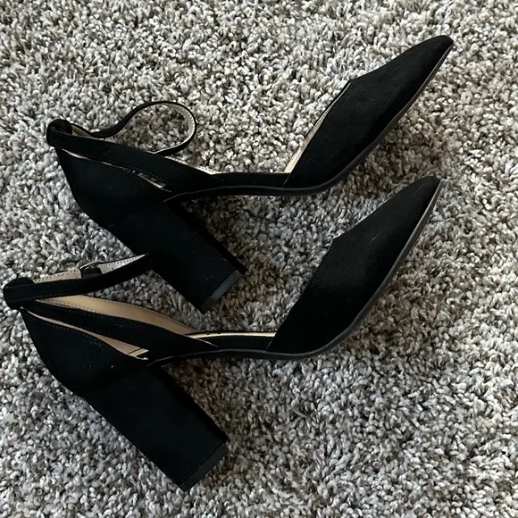 Black pumps with ankle strap and pointed toe
