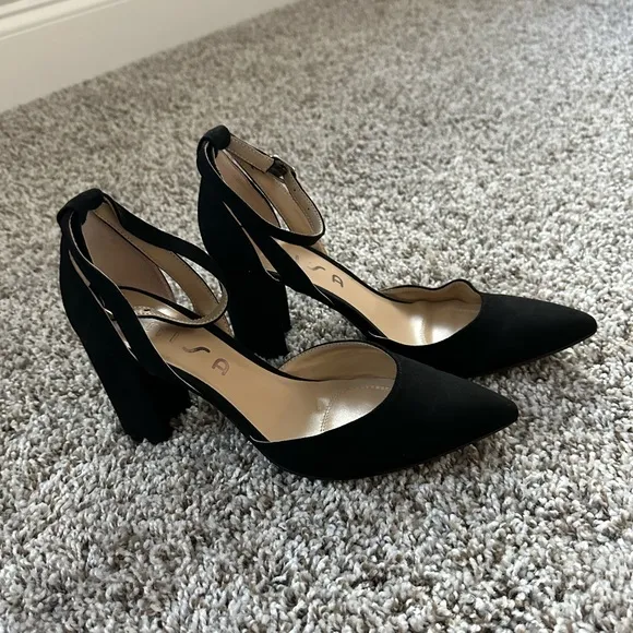 Black pumps with ankle strap and pointed toe